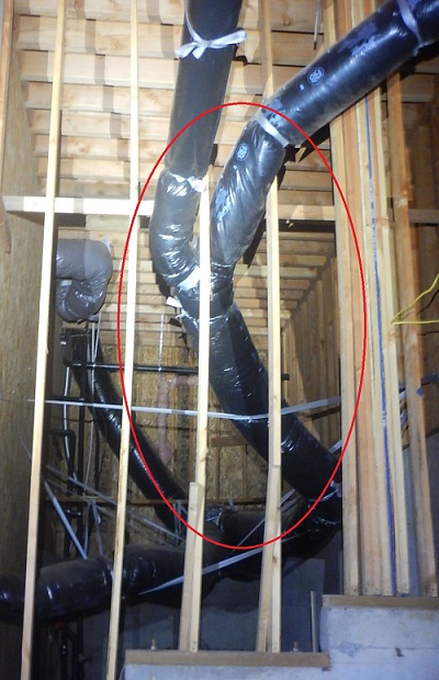 A photo of the crawlspace of a home with a plumbing issue circled